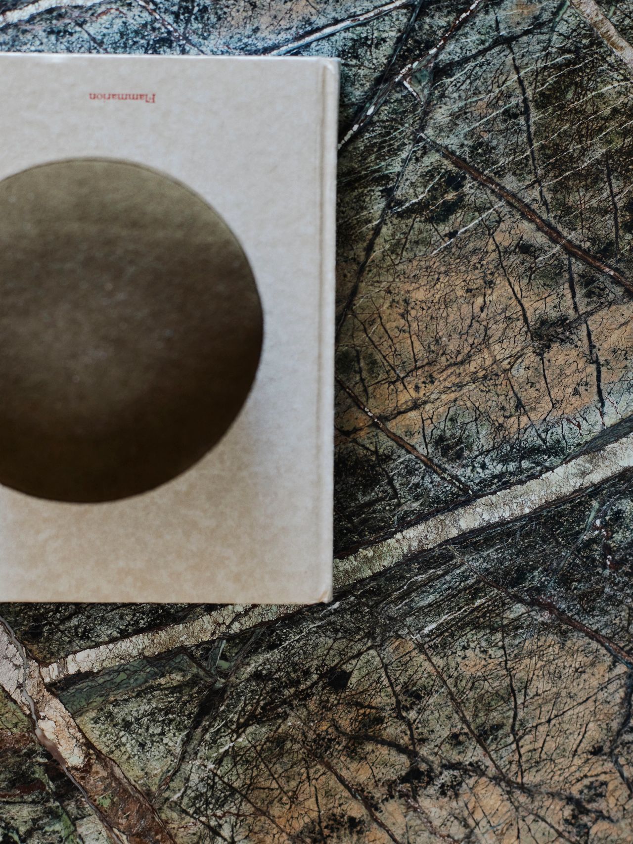 Detail of richly veined natural stone and curated decorative objects.