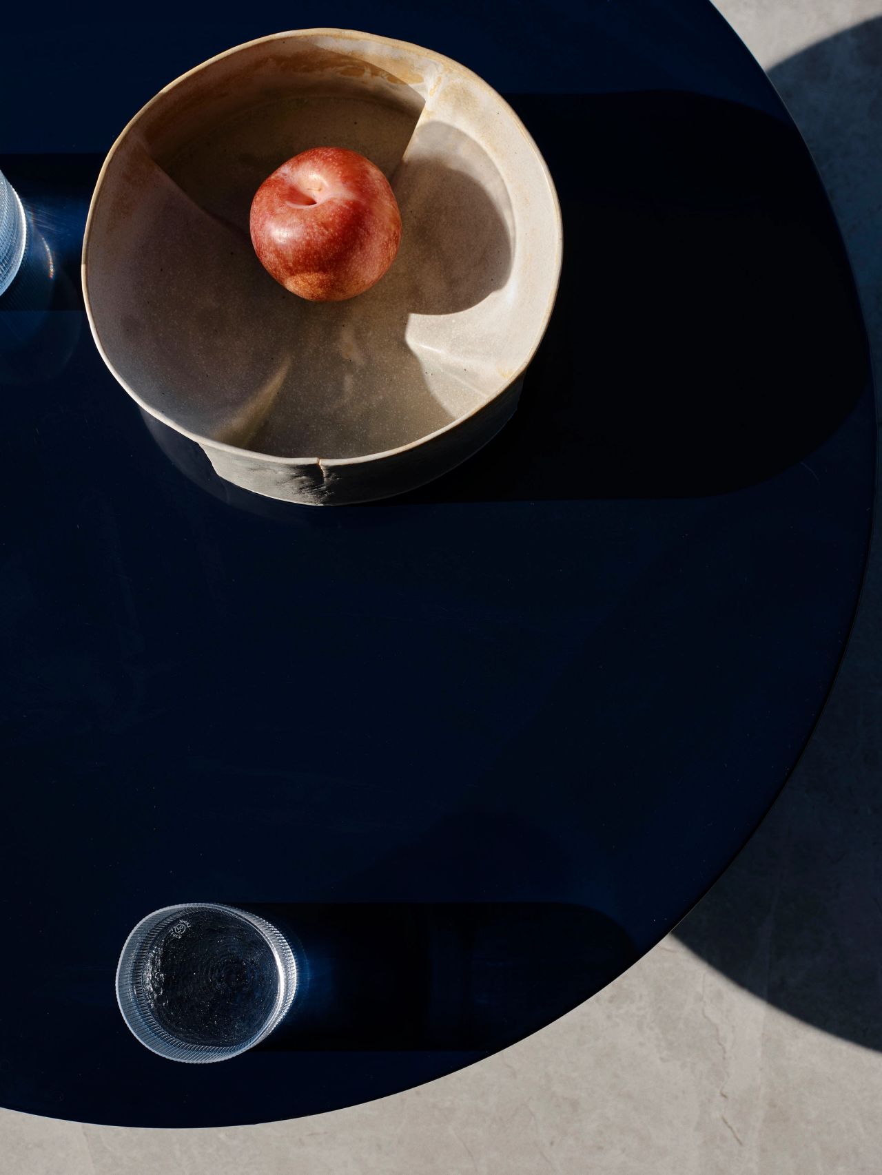 Cloud Surfer - birds-eye view of a dark blue coffee table with a water glass and bowl on it
