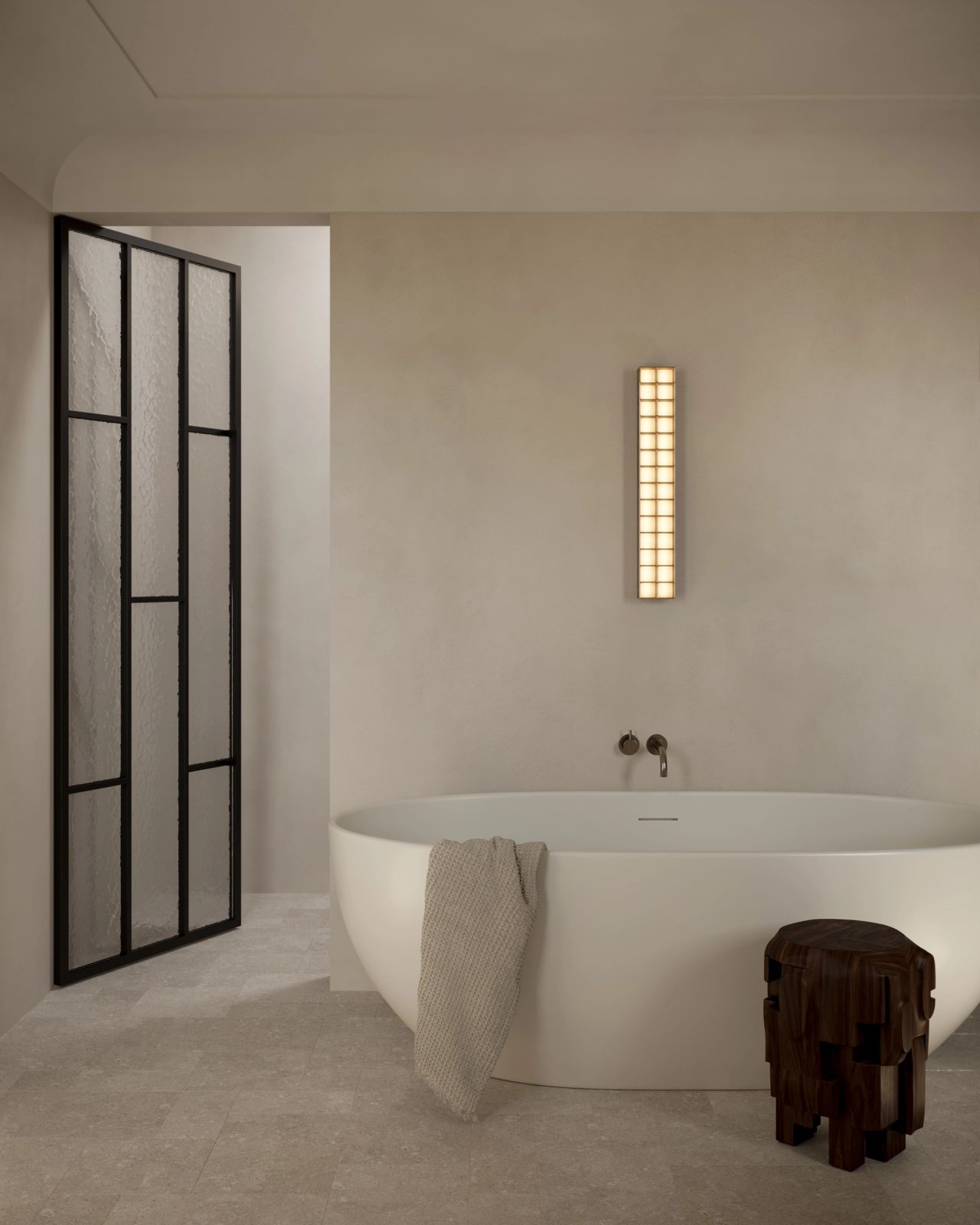 Serene contemporary bathroom with a freestanding oval bath, textured glass and black metal door.