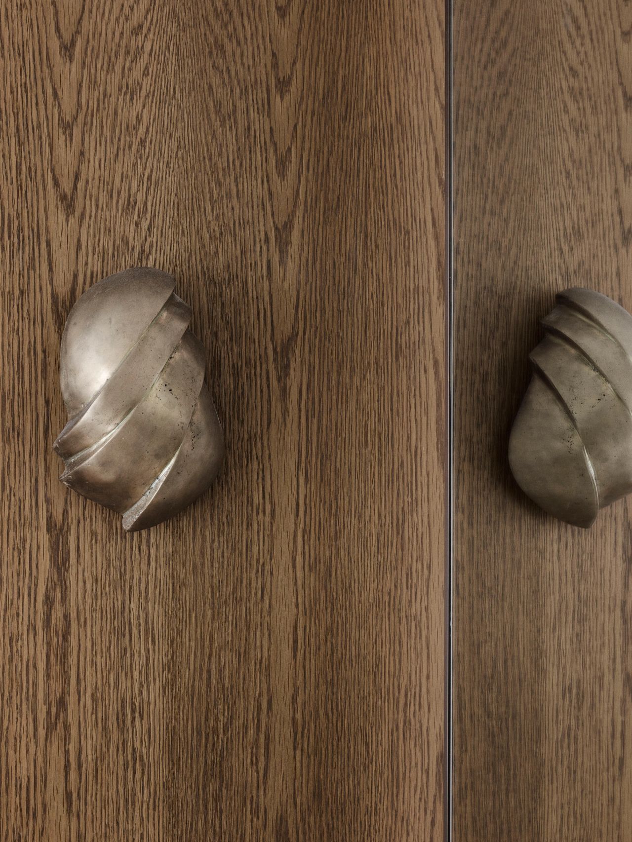 Dancing on the Ceiling sculptural brass wall sconce set against oak panelling