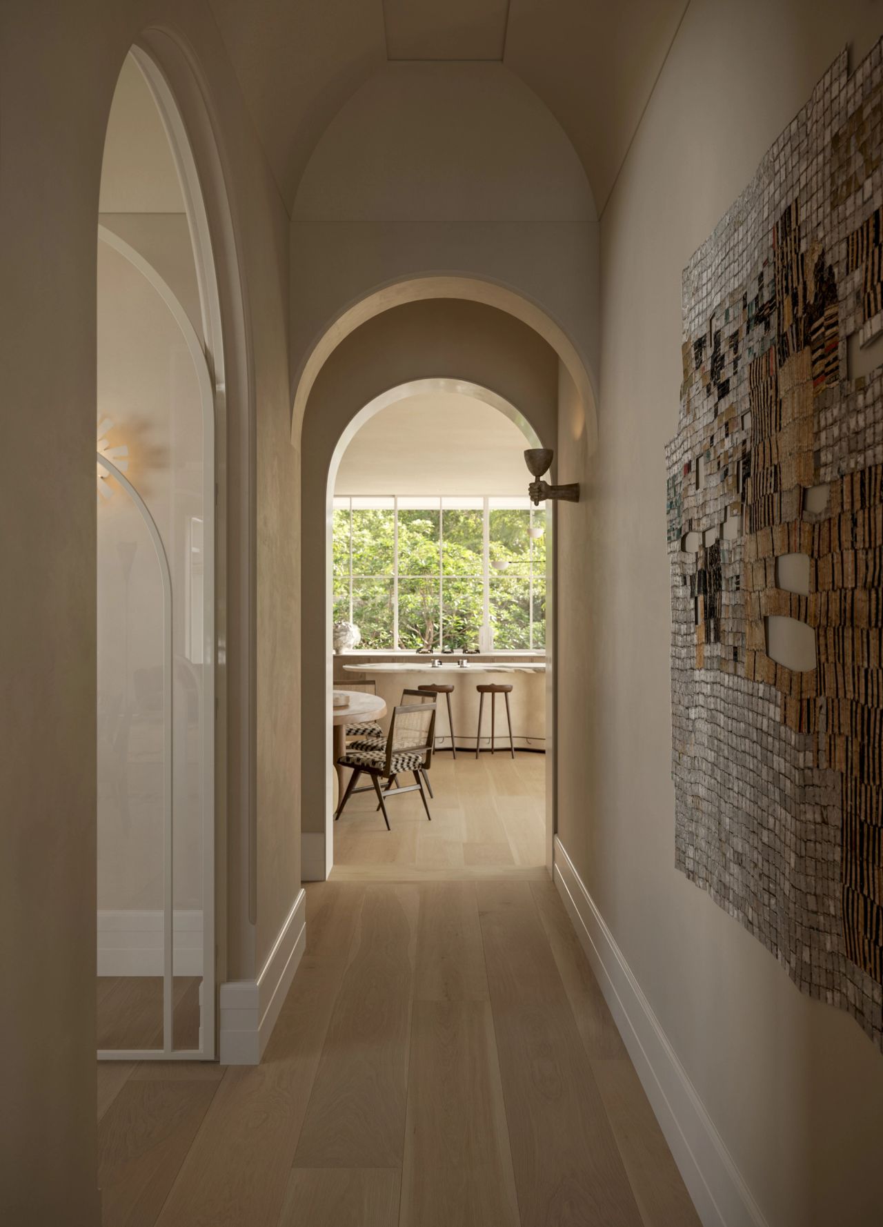 Lady M View down an arched, barrel-vaulted hallway with pale timber flooring, leading through to a sunlit kitchen and breakfast nook with garden views. A sculptural wall hanging and sculptural brass sconce line the corridor, with a curved glass door visible to the left