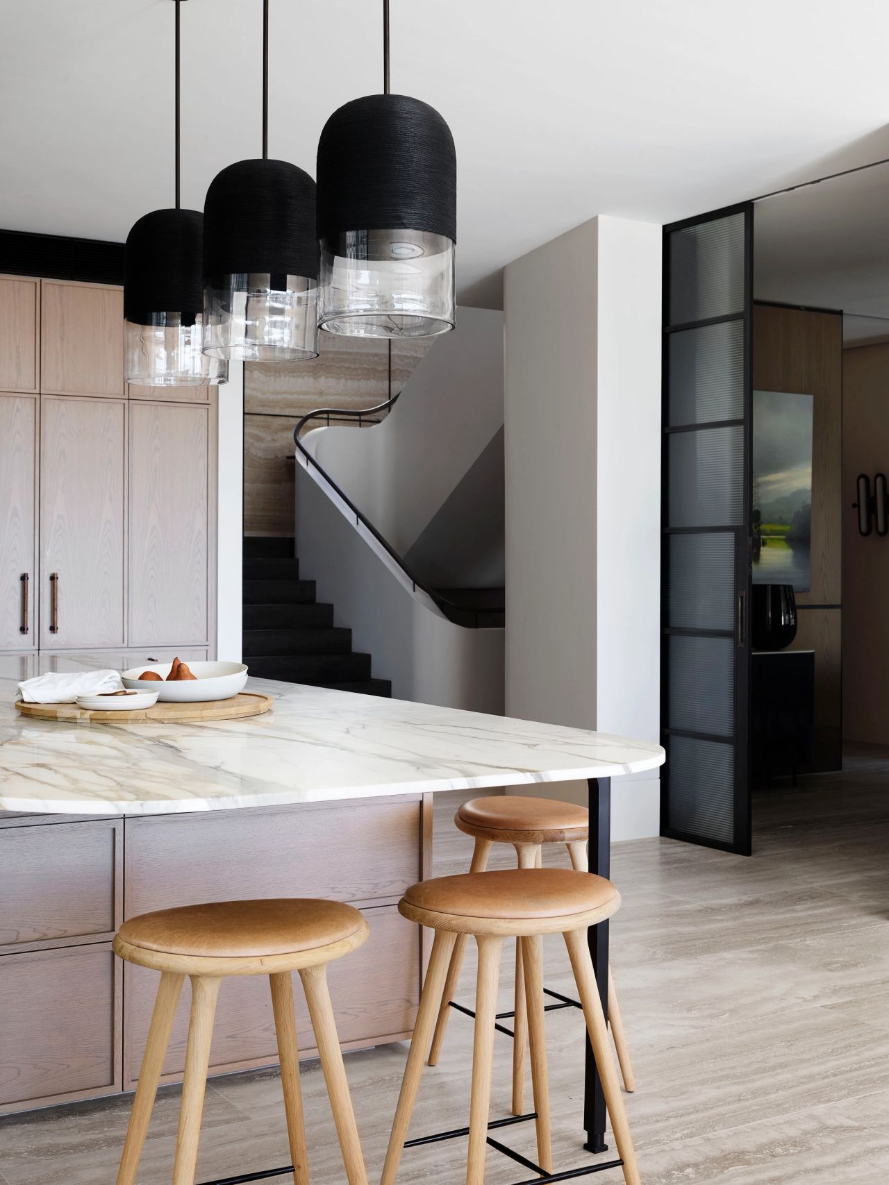 Hill House side shot of kitchen bench stools in a light timber with a light tan seat black pendant lights above