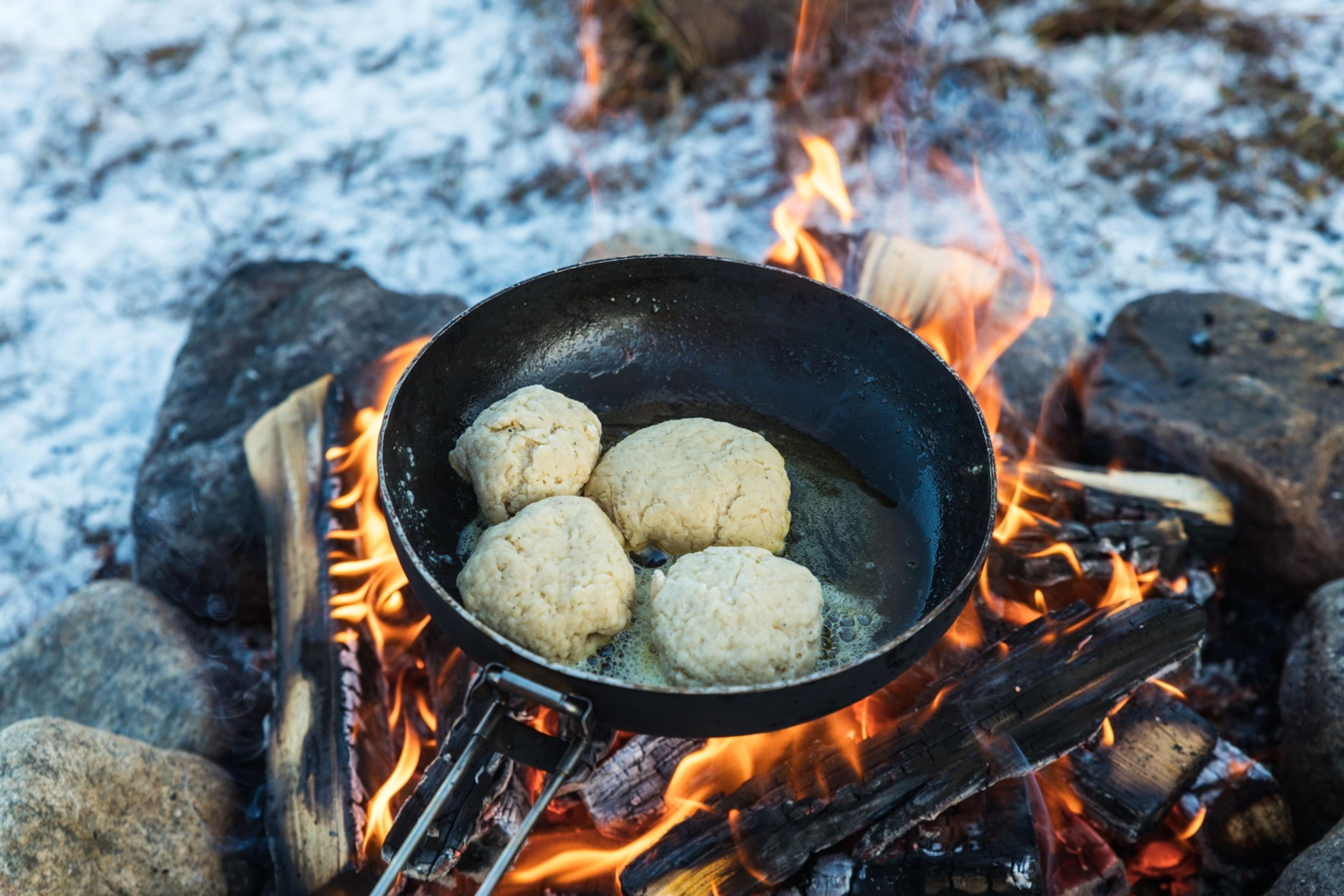Fire stk boller på en stekepanne over bål
