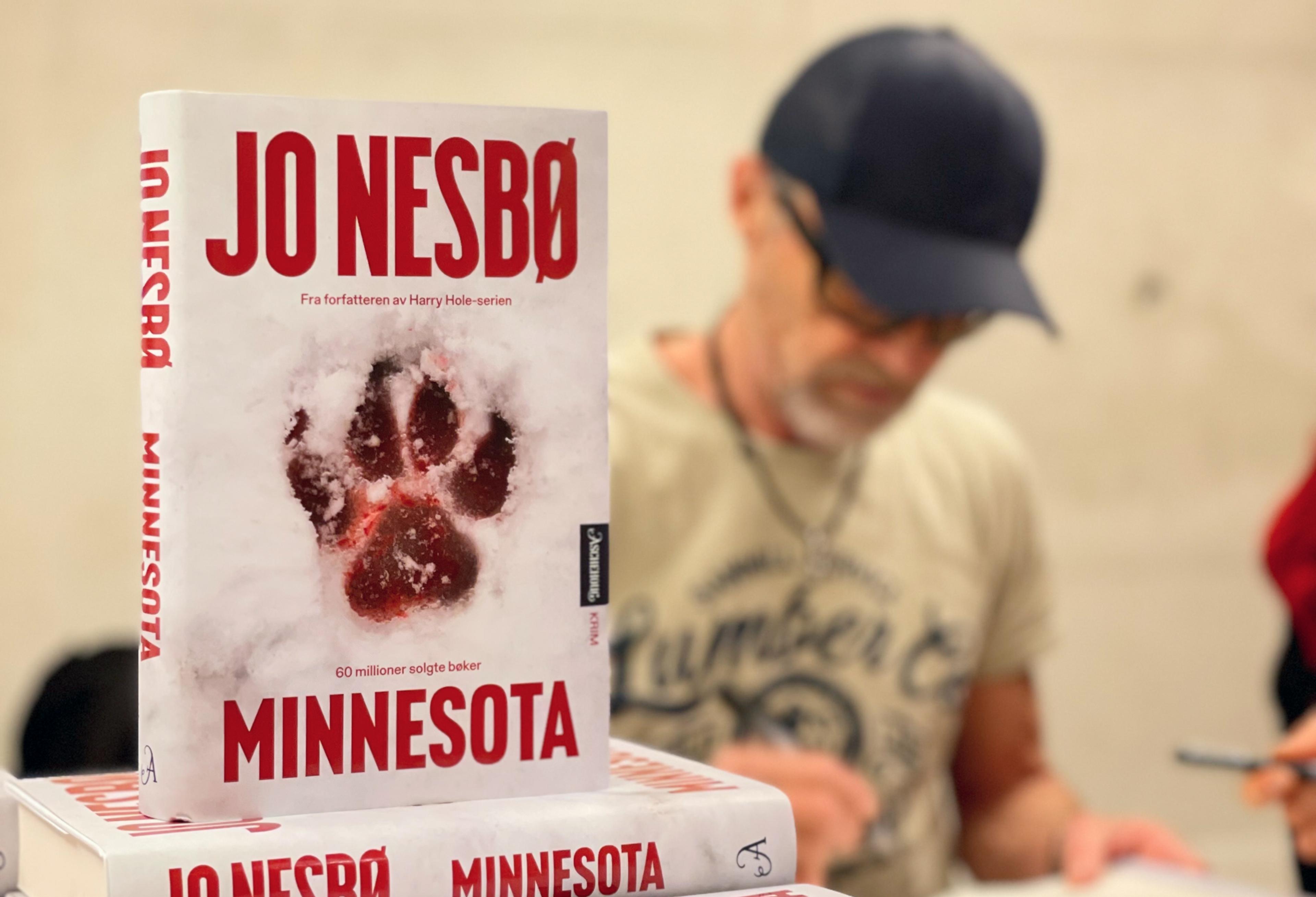 Minnesota i bokstabel med Jo Nesbø som sitter og signerer i bakgrunnen