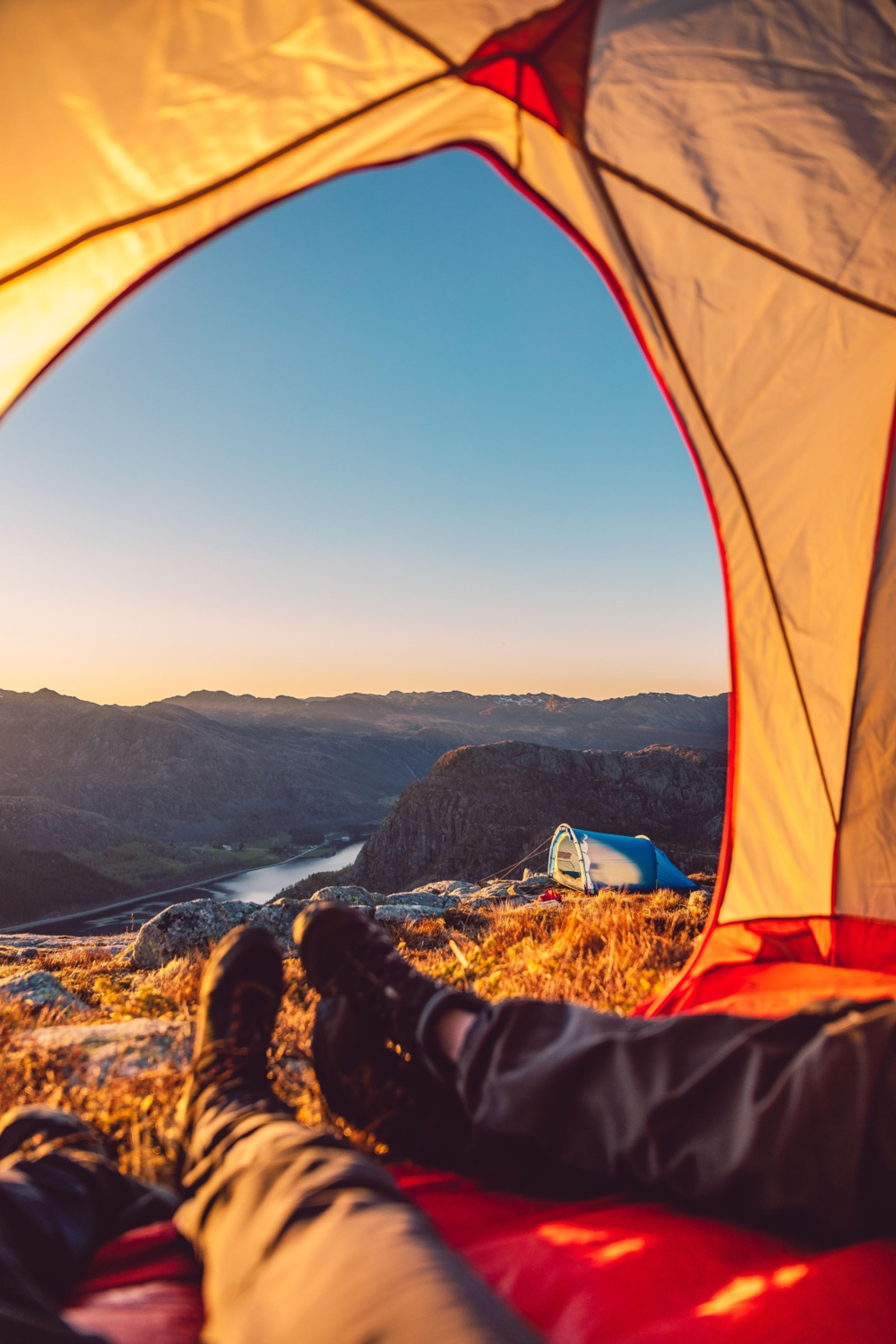 Bilde ut teltåpning med utsikt over fjelllandsskap.