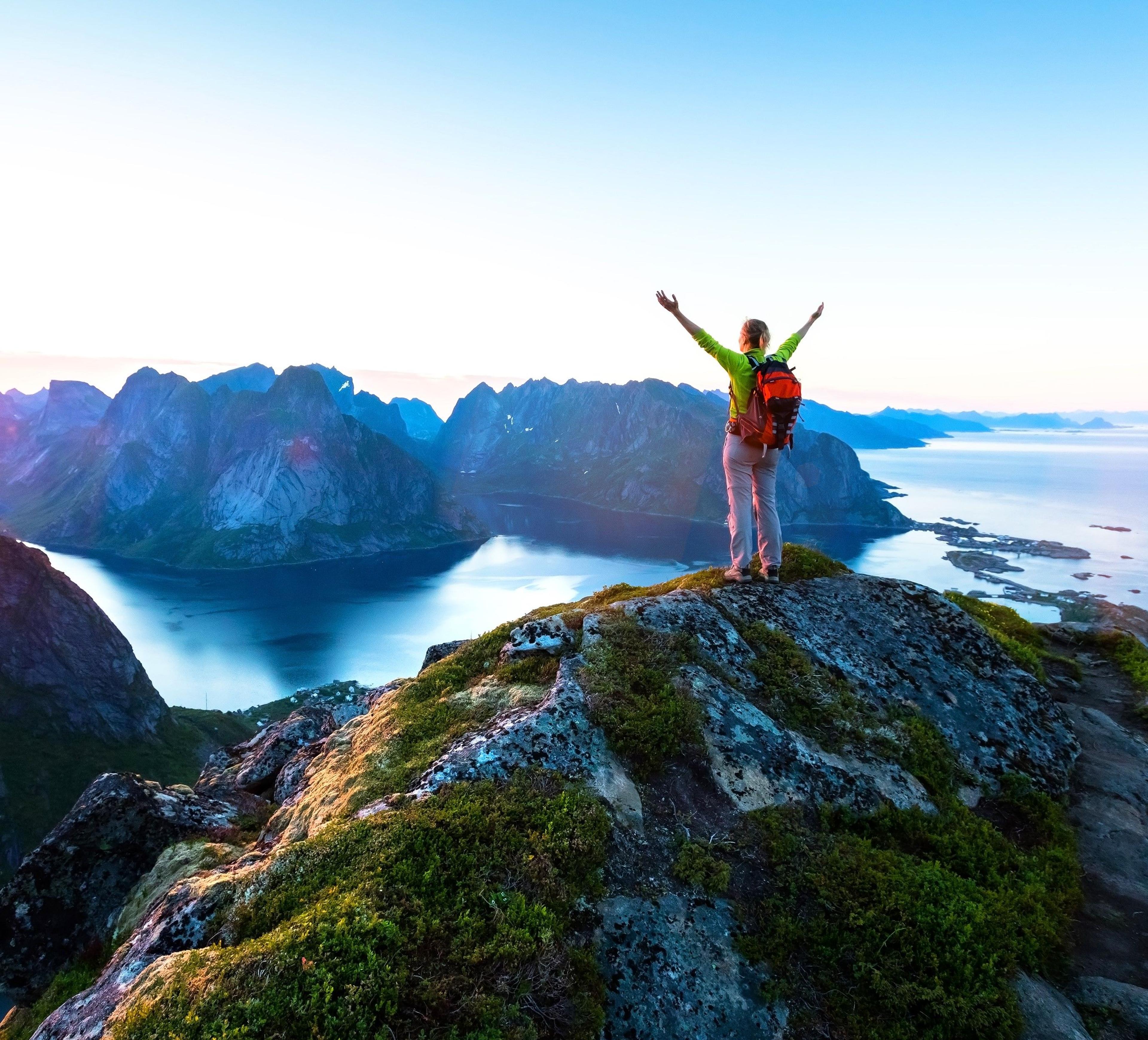 Foto av kvinne på toppen av et fjell i Norge