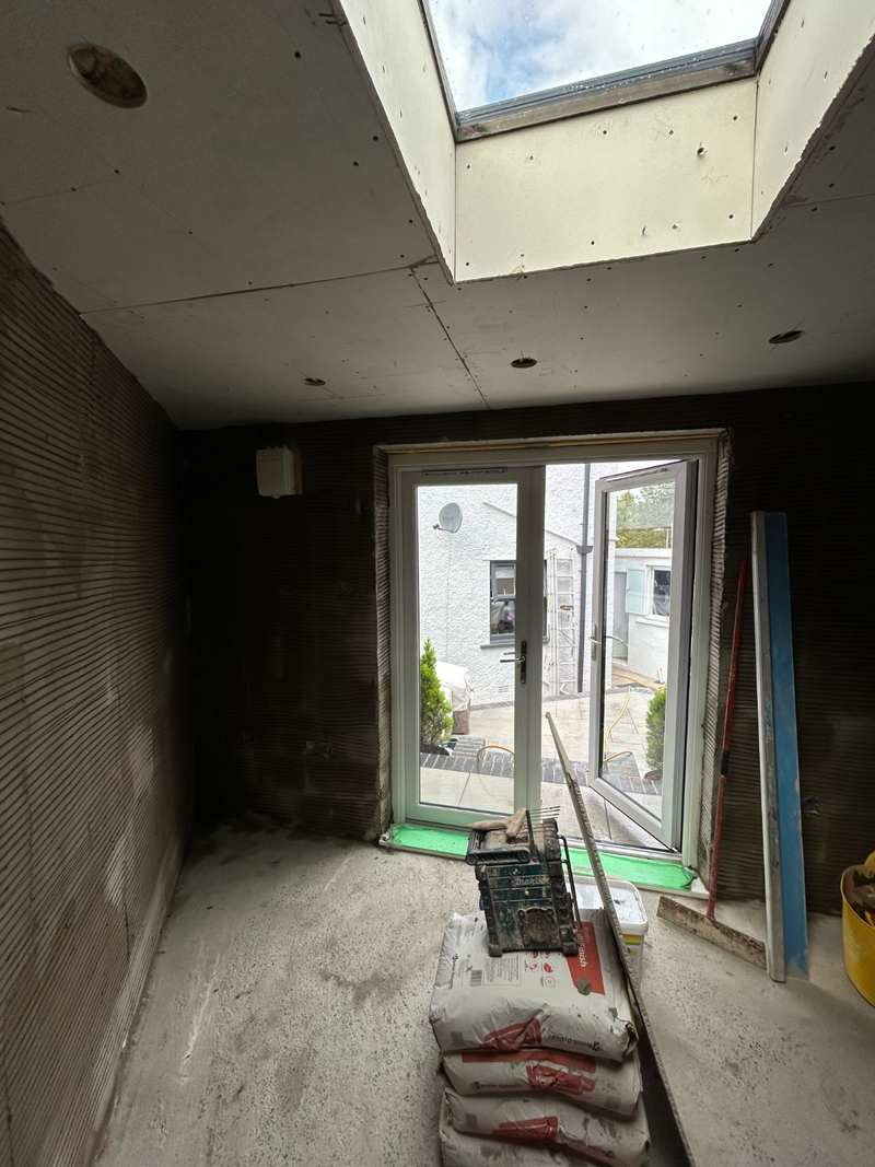 Extension interior with skylight and patio doors, walls in backing coat