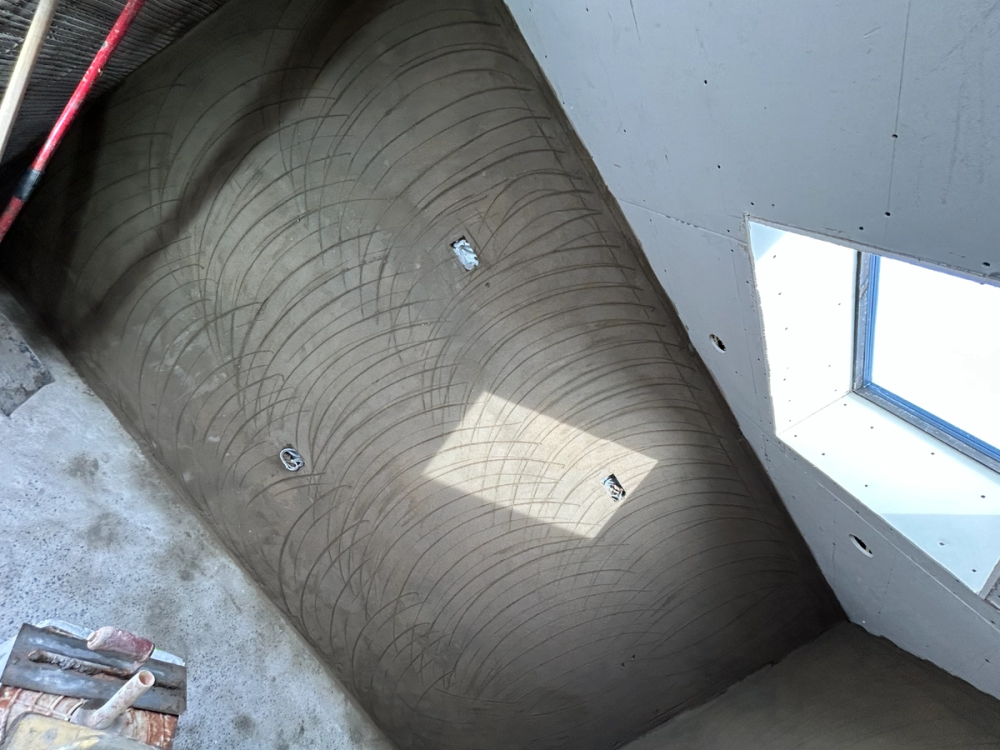 Scratch coat wall beneath a new skylight