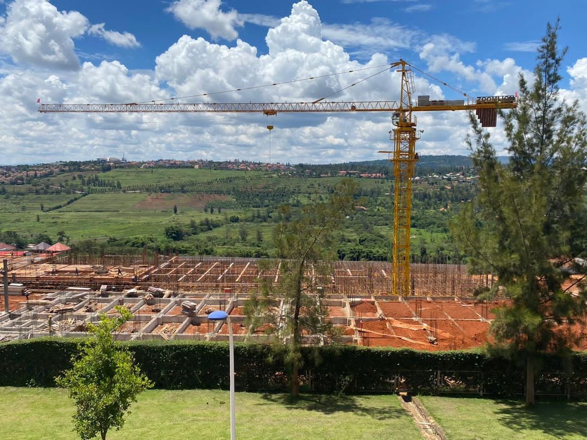 A large hospital project under construction in Rwanda, with a tower crane over the site