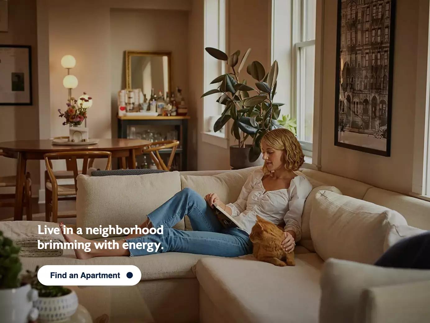 A woman reading on her couch with her cat