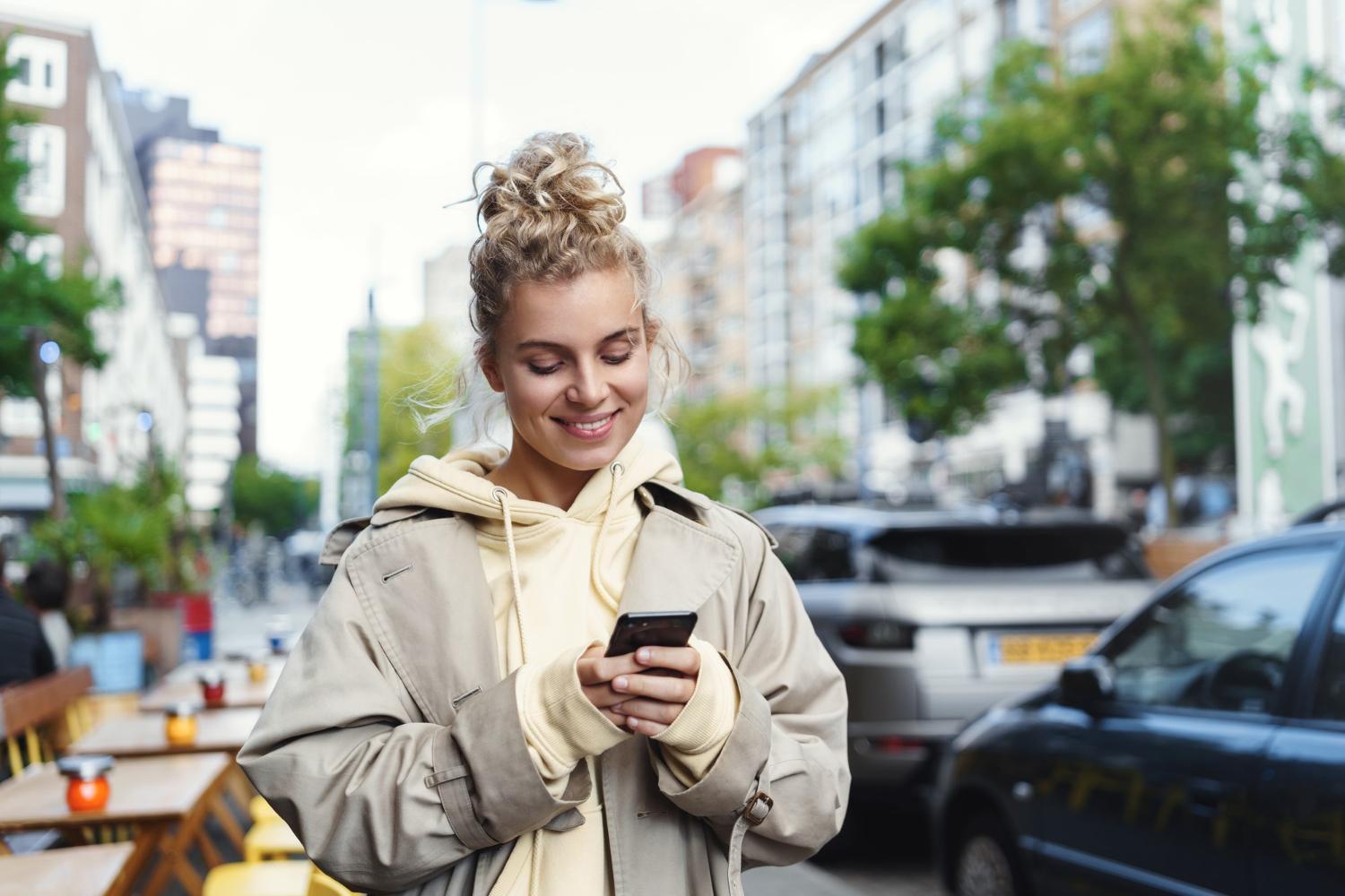 6414306a480f5f4cb101f0f1 smiling beautiful blond girl using mobile phone (1)