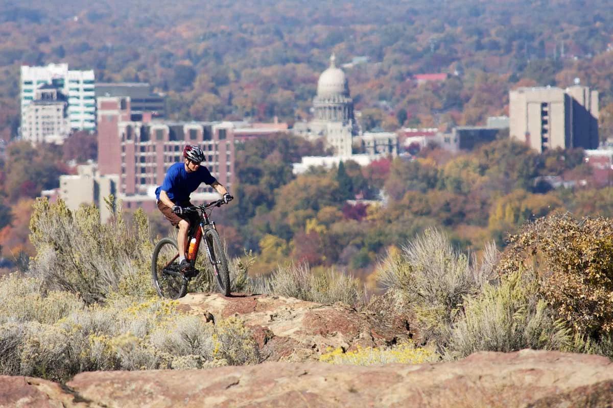 Man Riding a Bike on a Trail with Boise Capital Building in the Background | Idaho Storage Connection