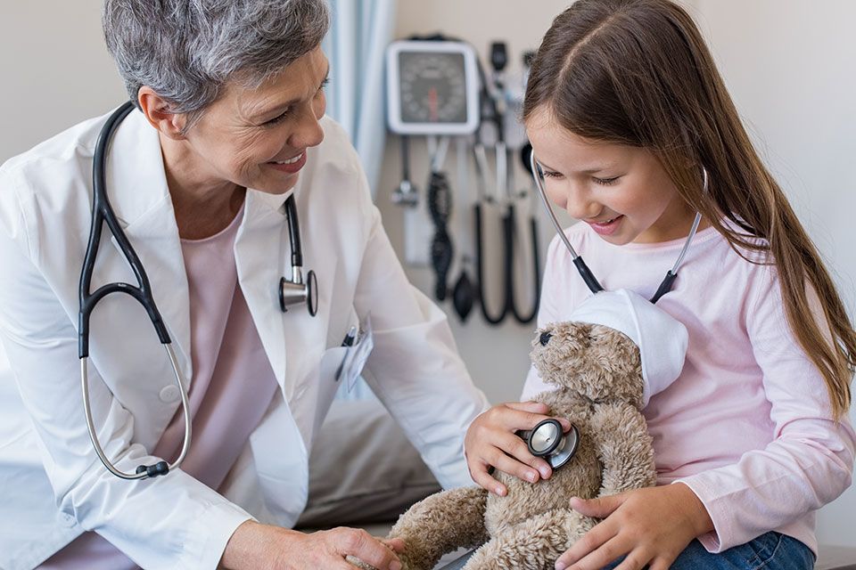 A doctor and child playing with a teddy bear | Idaho Storage Connection