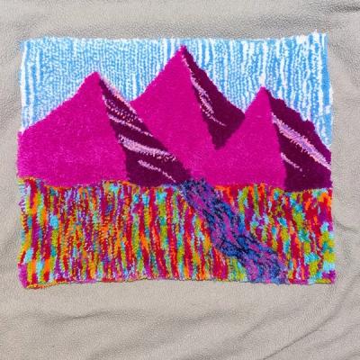 Hand-tufted rug with three magenta mountain peaks against a blue textured sky with colorful foothills in rainbow hues