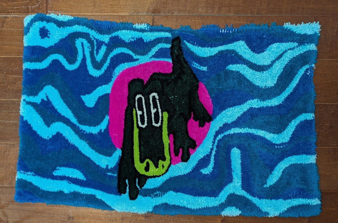 Rectangular hand-tufted rug with a dark silhouette of a drippy gator against a hot pink circle, surrounded by wavy blue and teal stripes