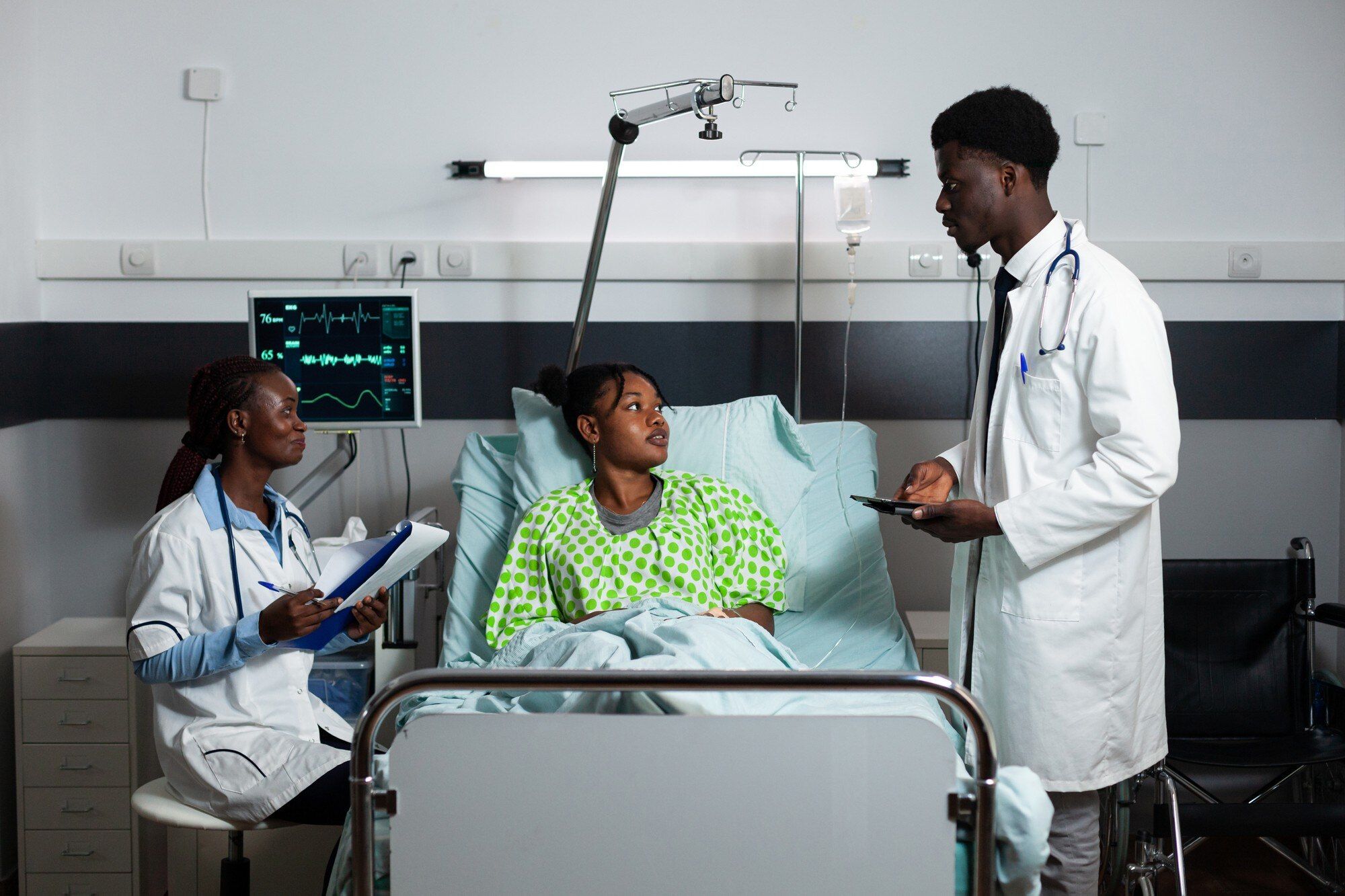 African doctors consulting a young adult patient in a hospital ward