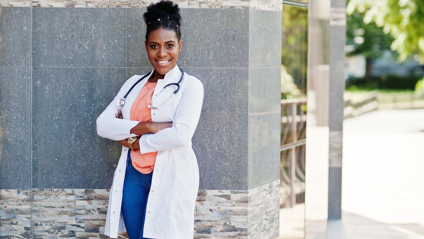 African American doctor in lab coat with stethoscope, outdoor portrait