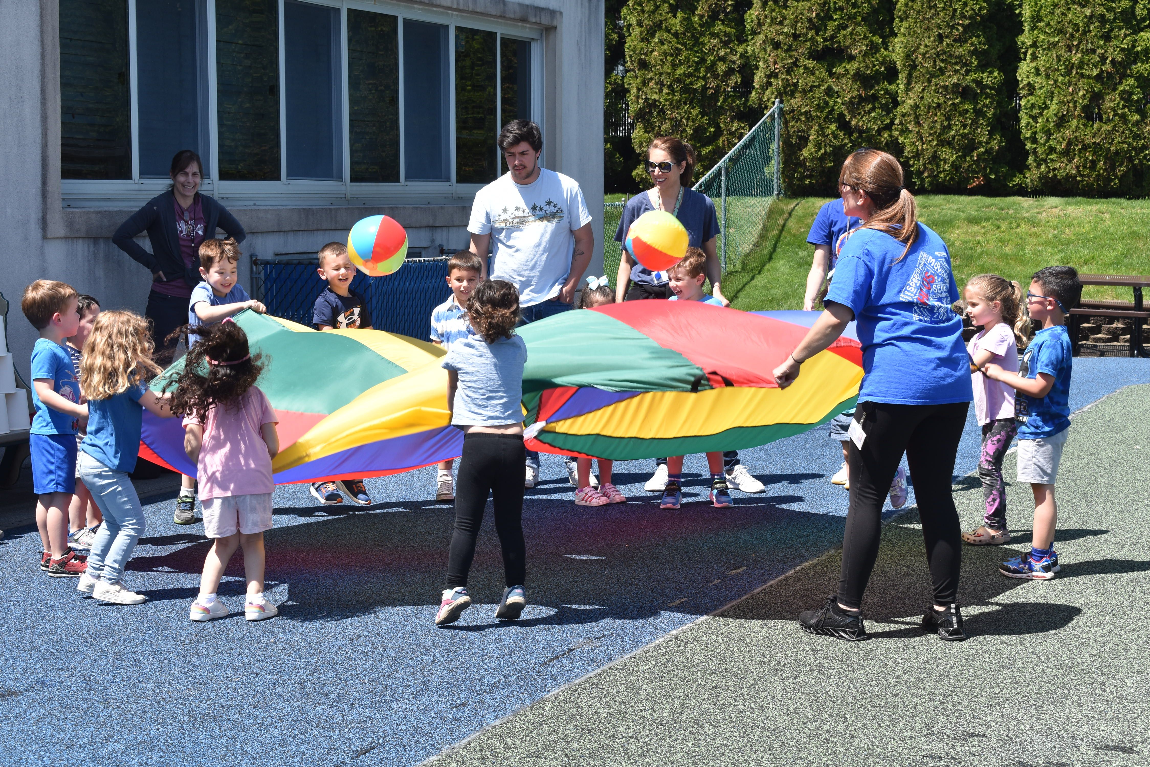 children playing with parachute outside