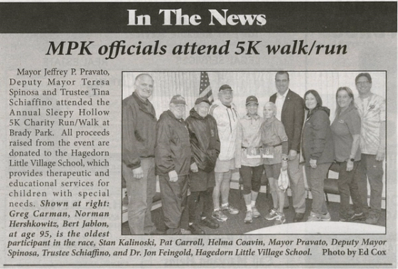 Newspaper clipping headlined “MPK officials attend 5K walk/run”, with a group photo of Massapequa Park officials and runners at the Sleepy Hollow 5K