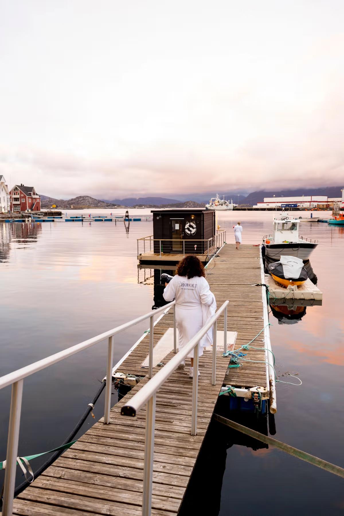 Dame som går ut på bryggen til saunaen