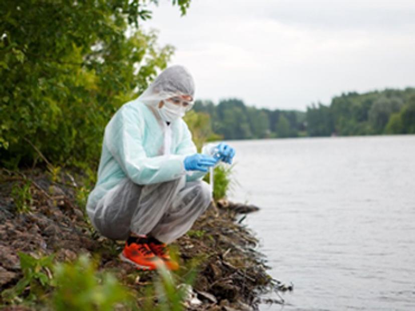 Scientist taking a water sample from a lake for analysis