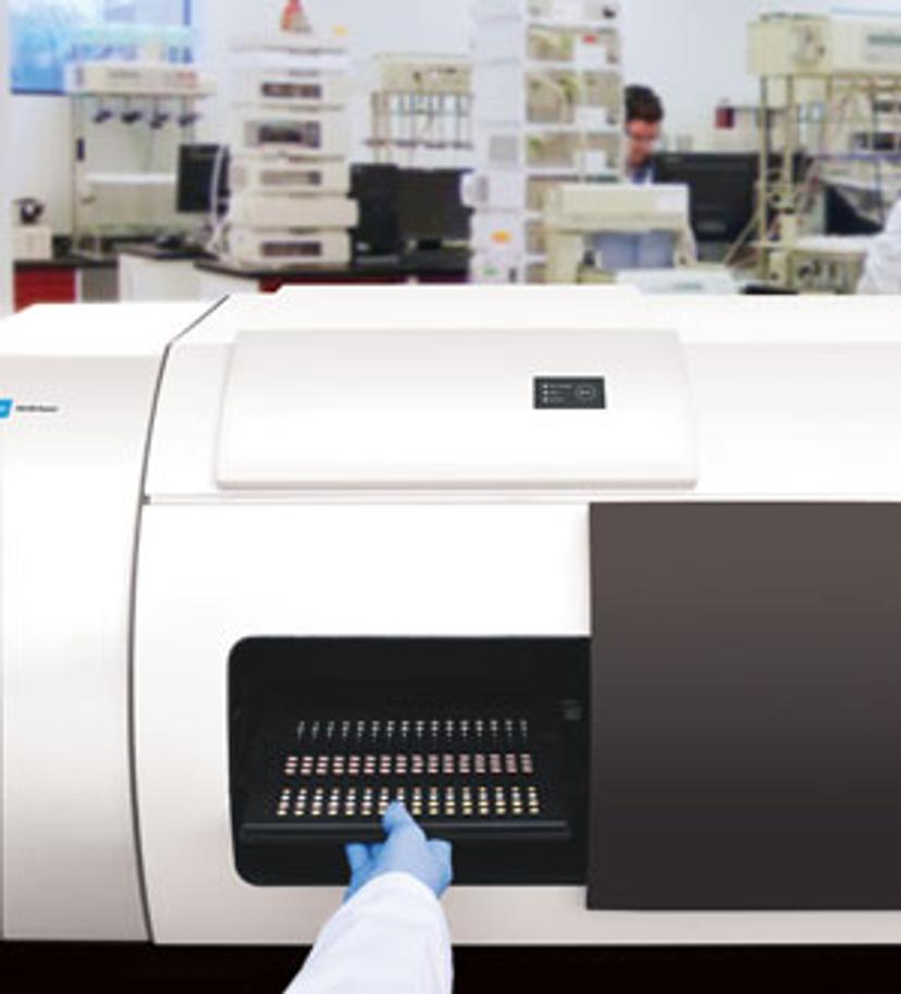 Scientist placing a tray of pharmaceutical tablets in the TRS100 for testing.