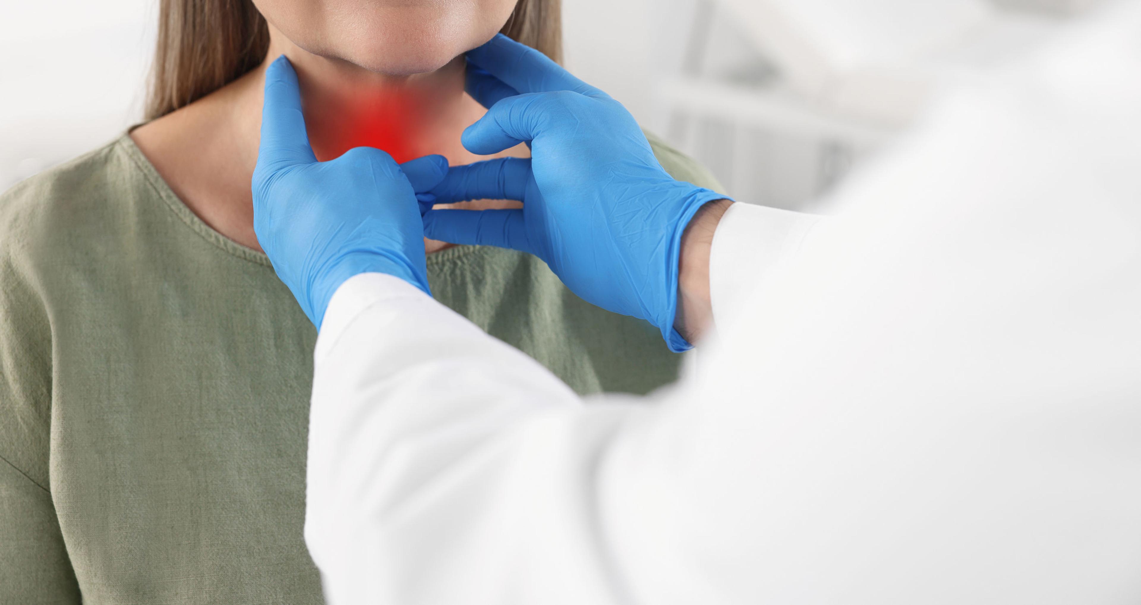 Image of doctor checking a patient's thyroid
