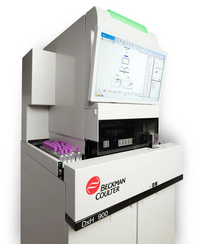 Beckman Coulter DxH 900 hematology analyzer shown from the left side with monitor and sample cassettes visible.