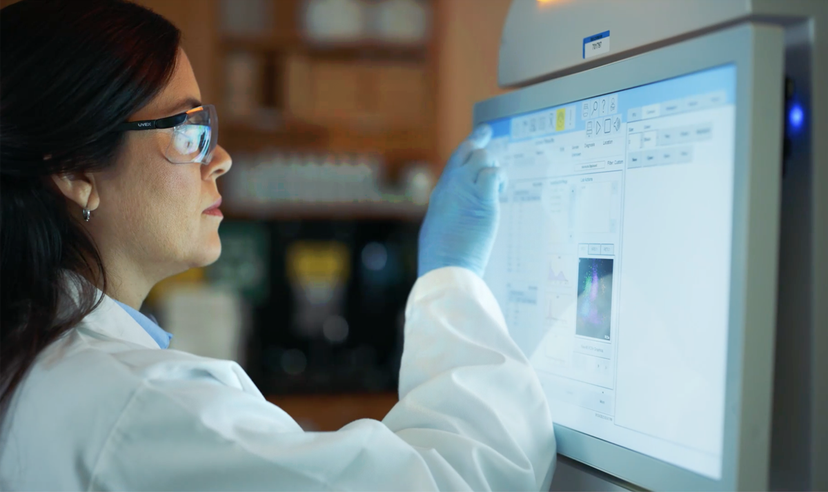 Lab professional reviewing hematology analyzer data on a touchscreen display