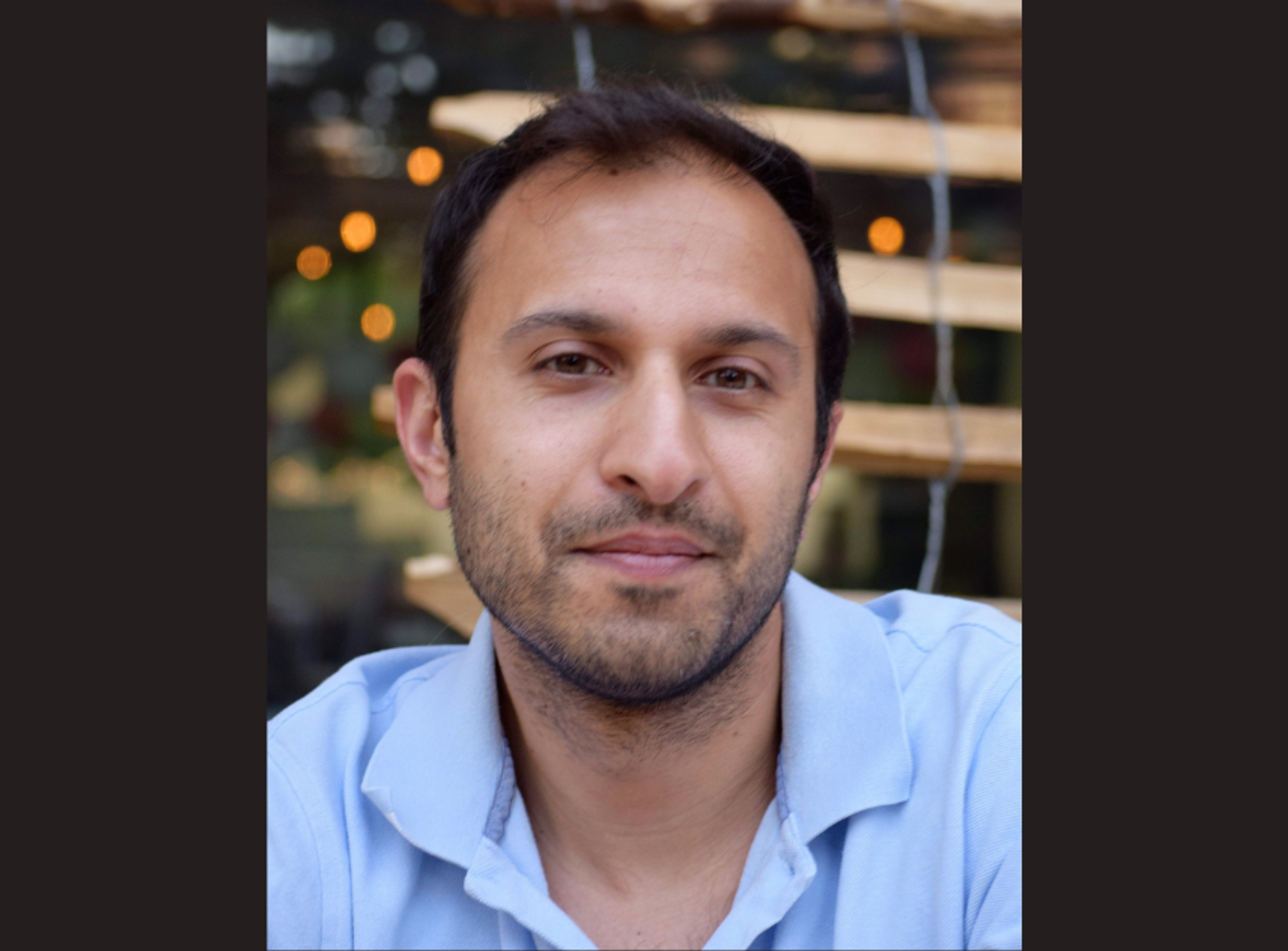 Image of scientist pipetting into microplate wells in biosafety cabinet