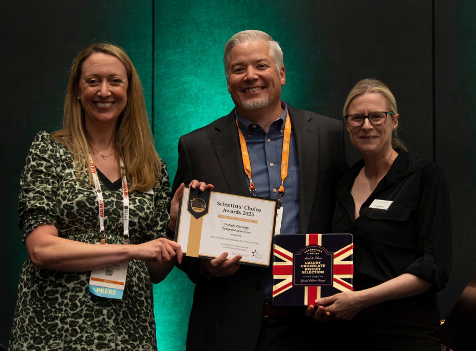 Photo of Zach Johnson, Illumina, being presented an award certificate by Kerry Parker and Sonia Nicholas, SelectScience