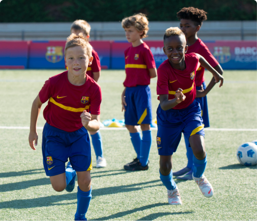 Group of smiling, young boys running in soccer jerseys