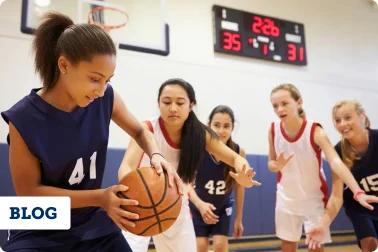 Youth female athletes playing basketball