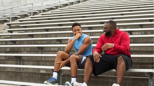 Football coach talking with his athlete
