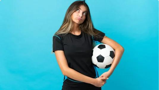 Girl with a soccer ball thinking about mental health