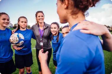 Female Soccer coach talking to her Youth athlete team