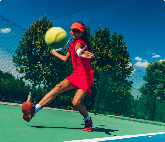 Action shot of a young girl about to strike a tennis ball