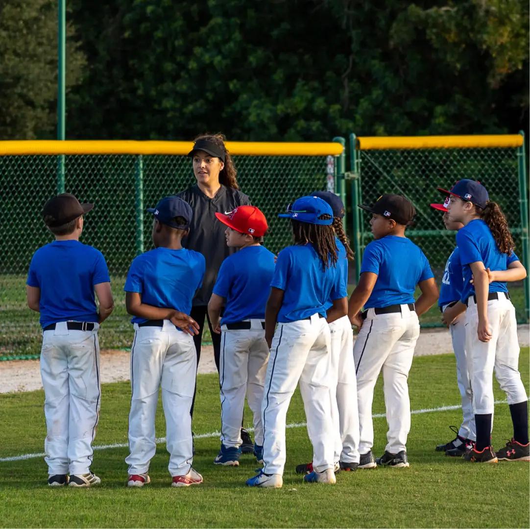 Female baseball coach speaking to a youth team