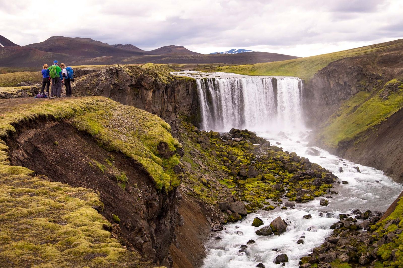 Waterfall with hikers in Icelandic nature