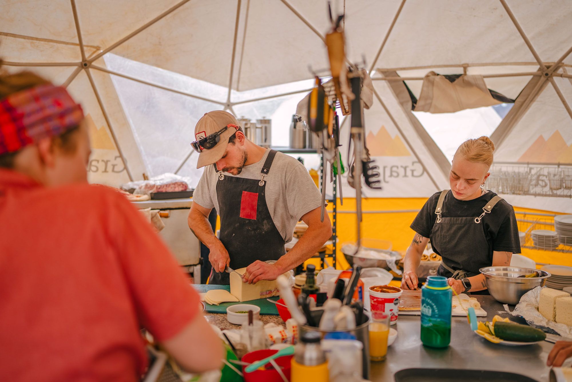 Chefs preparing meals in heated dining dome at Plaza de Mulas base camp