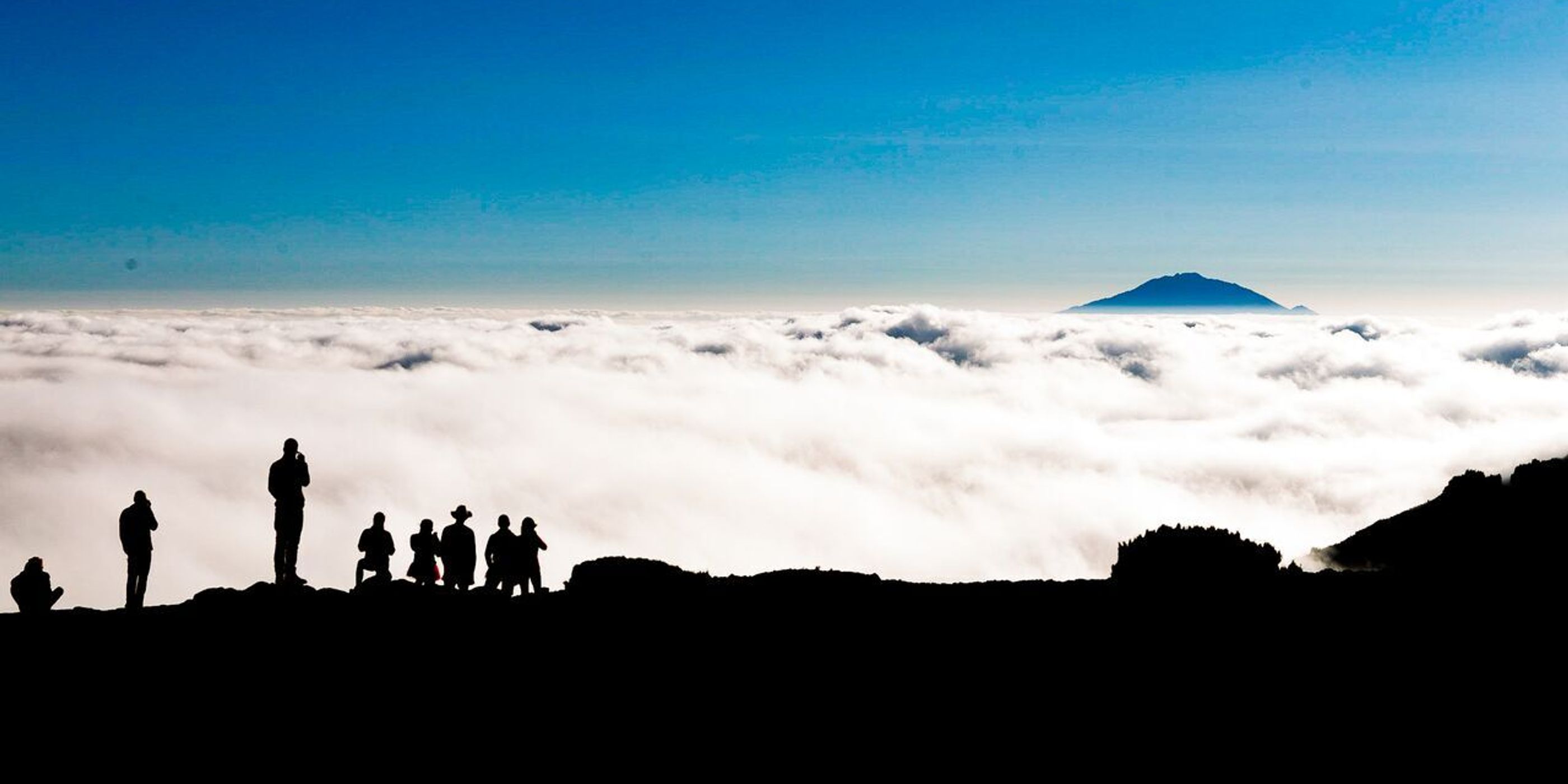 silhouettes of people in the clouds on Kilimanjaro