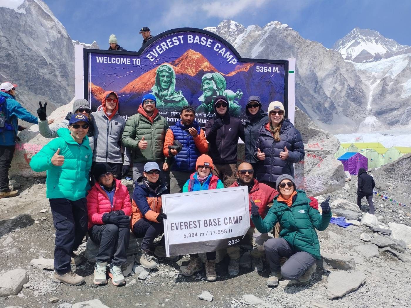 Group posing with Everest base camp sign