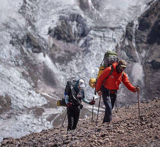 Climbers trekking toward Aconcagua with glacier behind