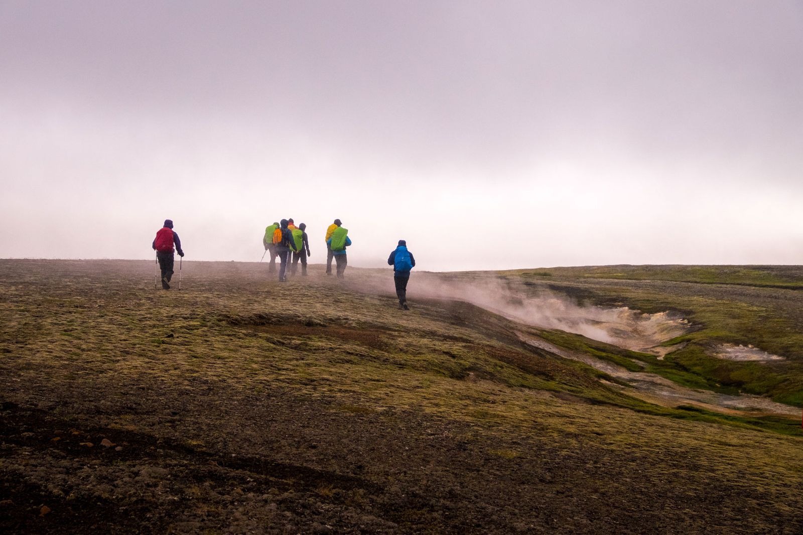 Hiking group trekking through misty volcanic landscape