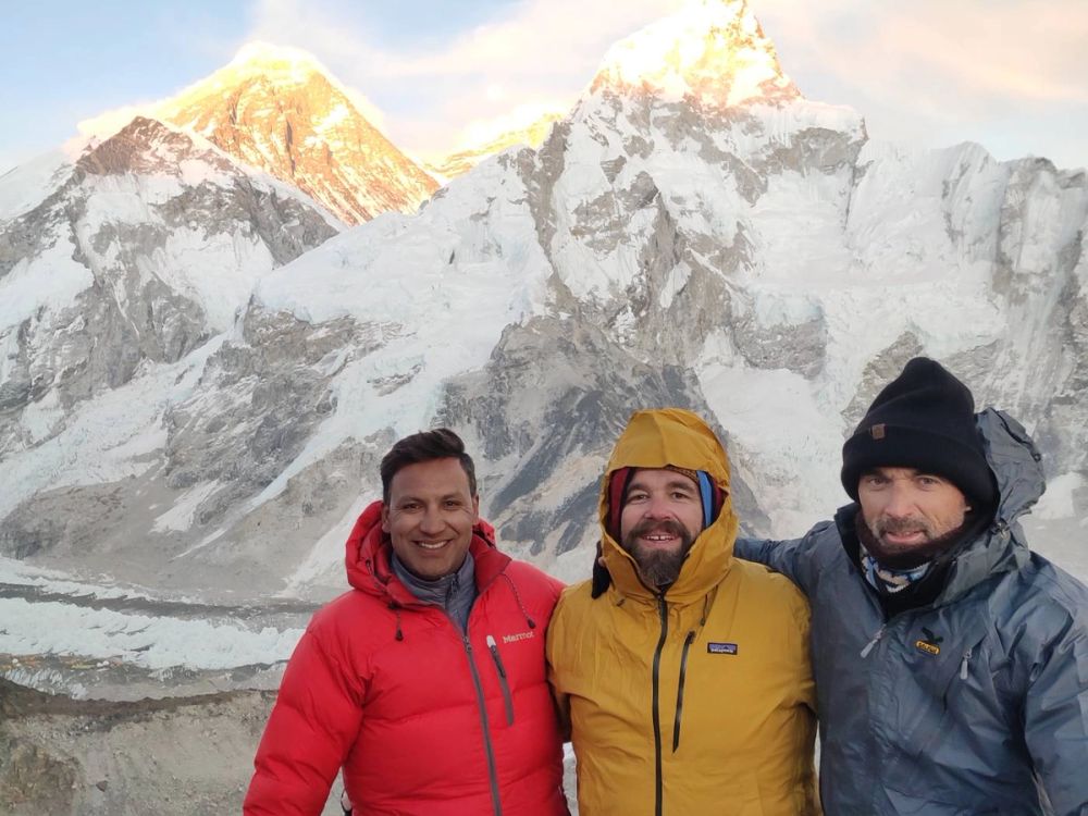 Hikers smiling with a Sunrise over peaks