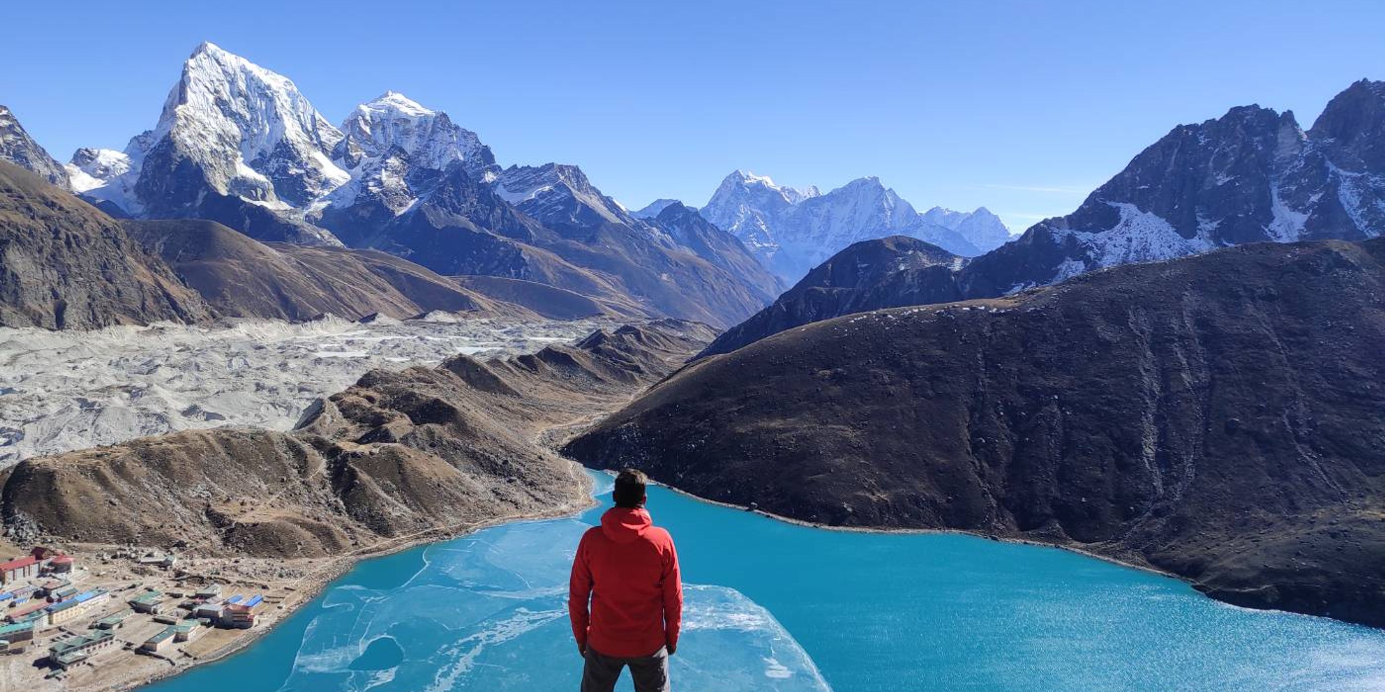 person facing a clear blue lake in nepal
