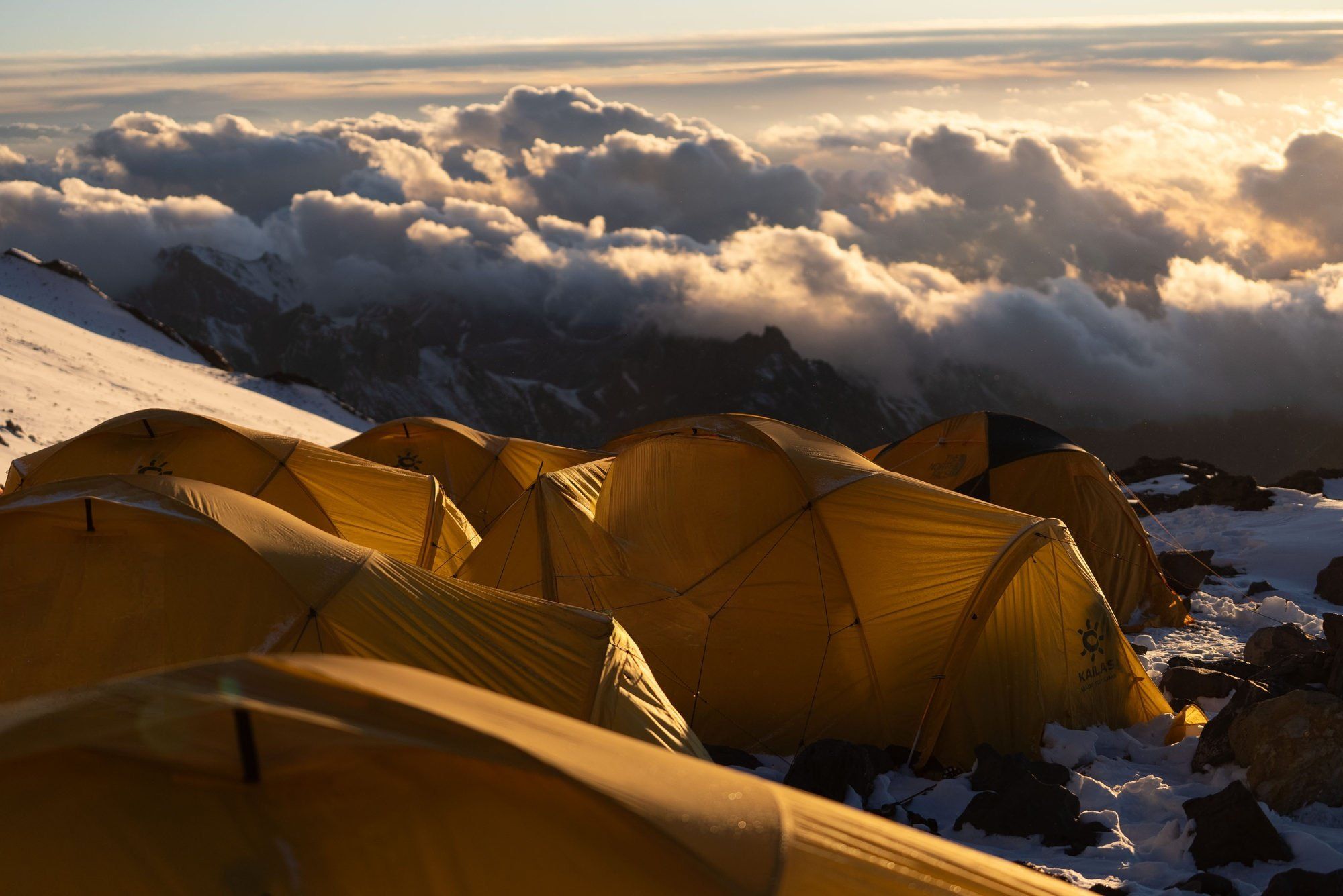 Mountain camp at sunrise with dramatic clouds on Aconcagua