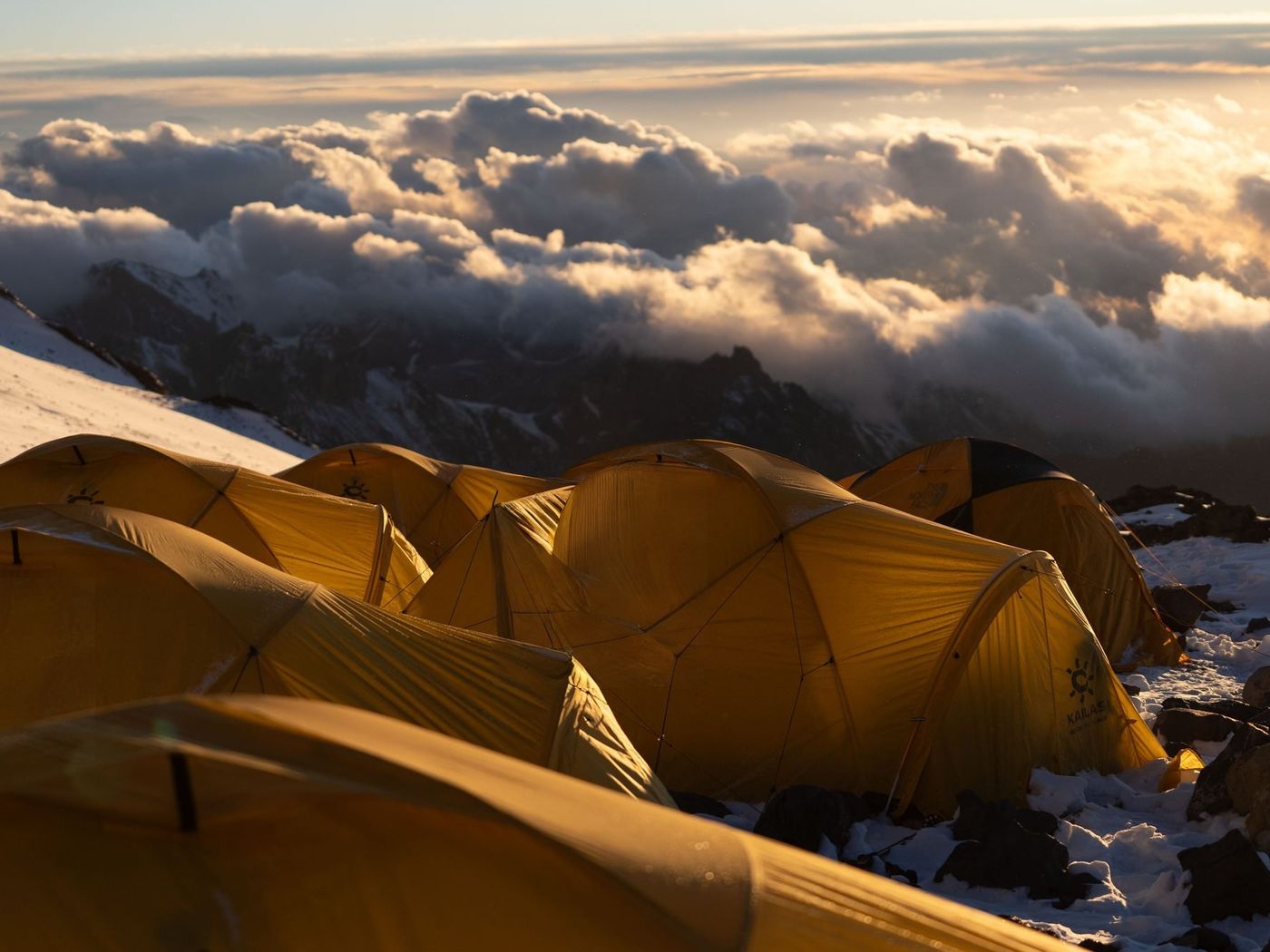 Mountain camp at sunrise with dramatic clouds on Aconcagua