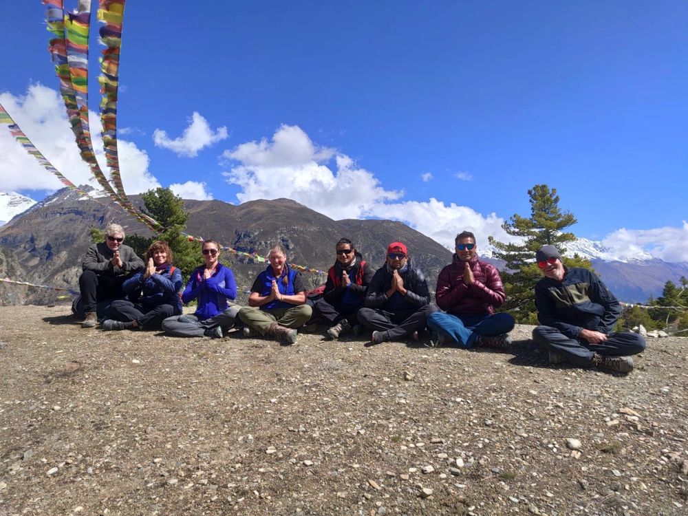 Group in pray pose under pray flags