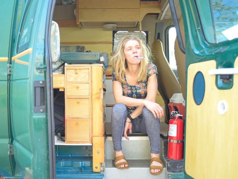 Brushing teeth tired looking out of van 